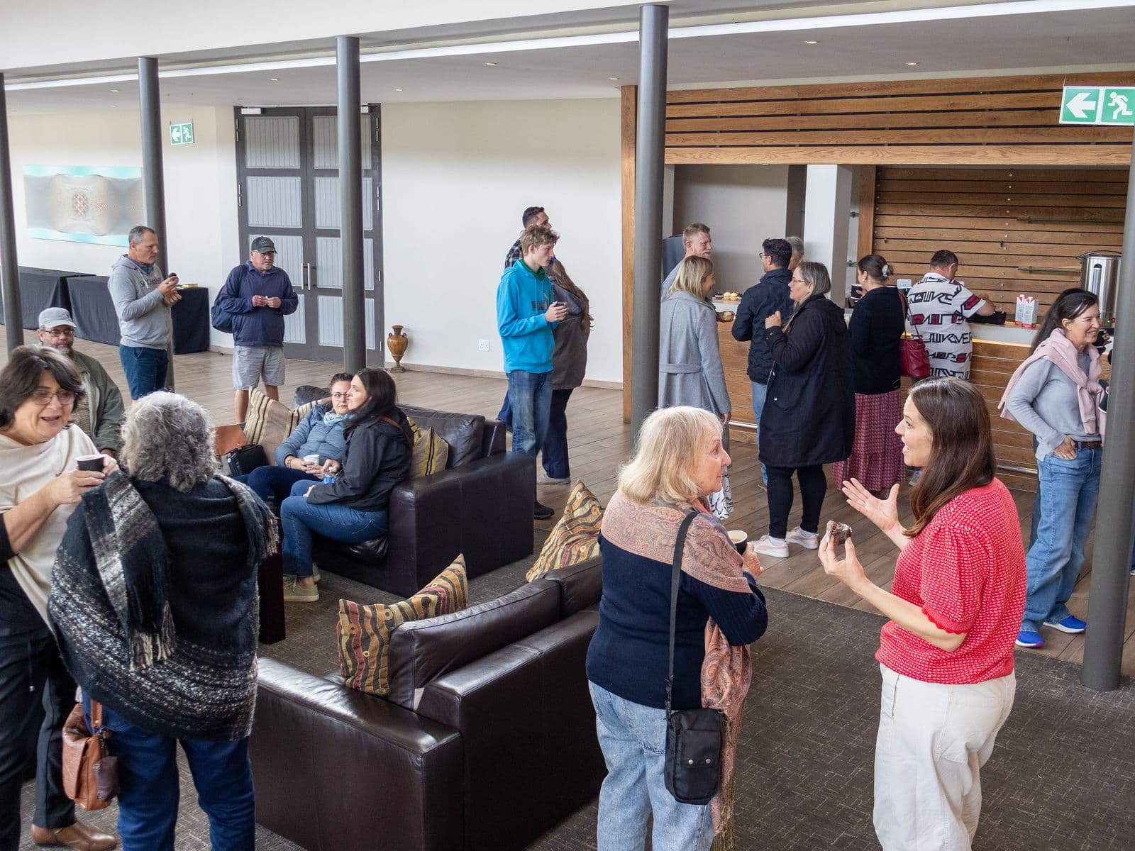 People talking together in the foyer lounge after a Sunday gathering at His Kingdom Church